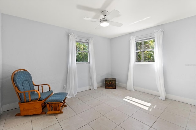 sitting room featuring ceiling fan, light tile patterned flooring, and a healthy amount of sunlight