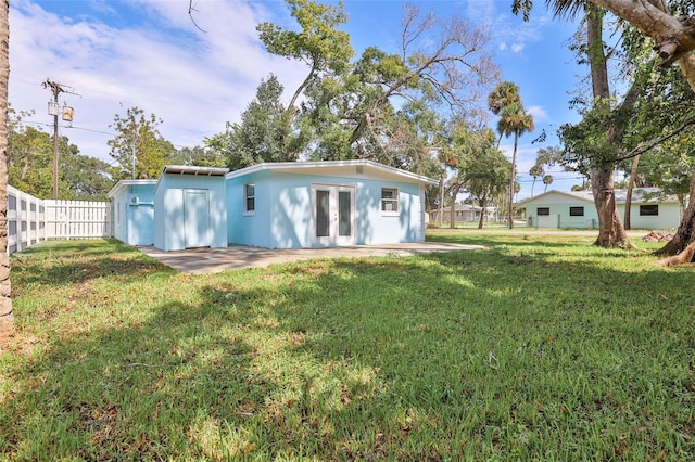 rear view of property featuring a lawn and a patio