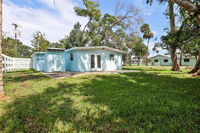 back of property with a yard and a patio area