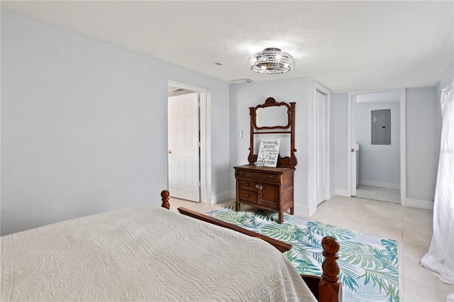 bedroom with light tile patterned flooring, electric panel, and ensuite bath