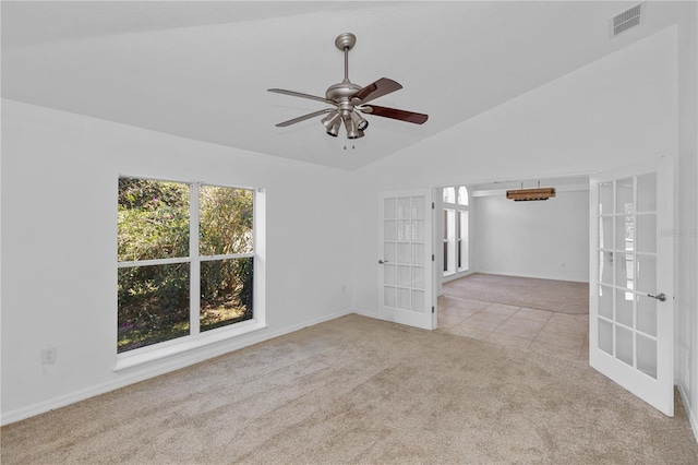 carpeted spare room with ceiling fan, french doors, and vaulted ceiling