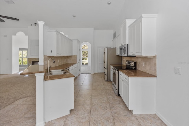 kitchen featuring sink, ceiling fan, appliances with stainless steel finishes, plenty of natural light, and white cabinetry