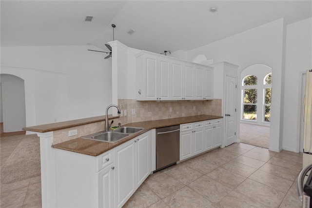 kitchen with white cabinetry, sink, stainless steel dishwasher, kitchen peninsula, and lofted ceiling