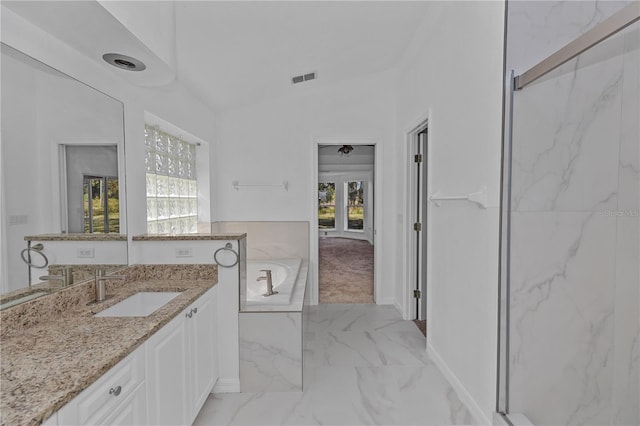 bathroom featuring a bathing tub, vanity, and lofted ceiling