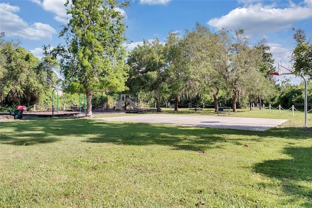 view of community featuring a playground, basketball court, and a yard