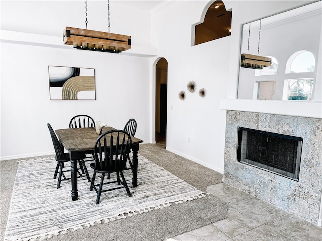 carpeted dining space featuring a fireplace and crown molding