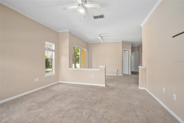 carpeted spare room with a textured ceiling, ceiling fan, and crown molding