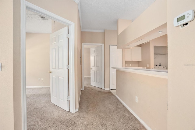 corridor featuring light carpet and a textured ceiling