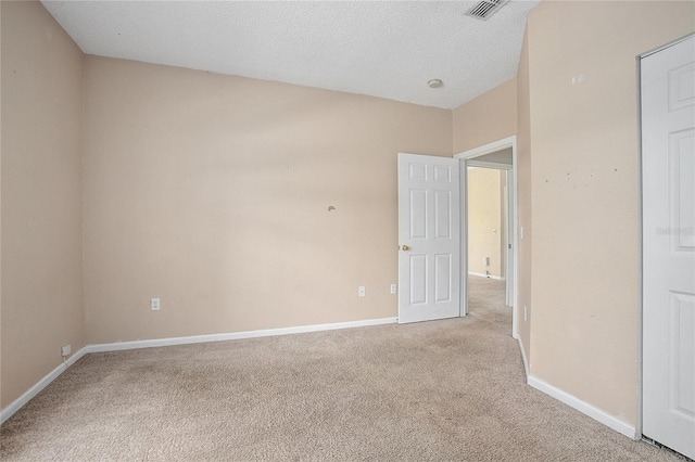 carpeted spare room featuring a textured ceiling