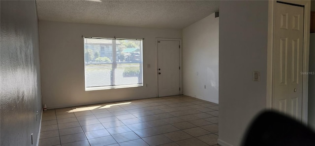 spare room with light tile patterned floors and a textured ceiling