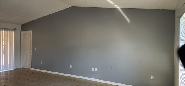 tiled spare room with baseboards and vaulted ceiling