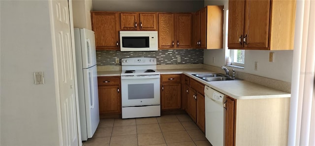 kitchen with light countertops, light tile patterned floors, brown cabinets, white appliances, and a sink