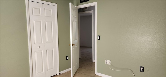 unfurnished bedroom with light tile patterned flooring, visible vents, and baseboards