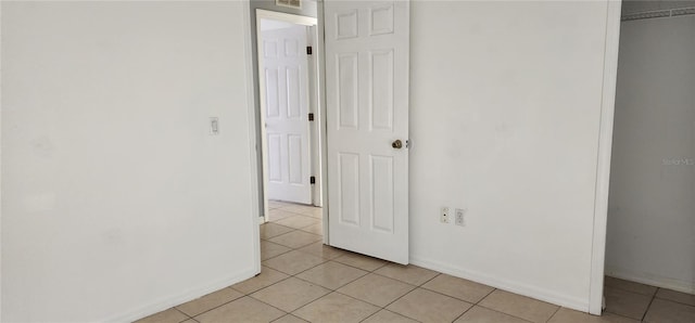 interior space with light tile patterned flooring, baseboards, and a closet