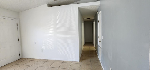 interior space with light tile patterned flooring and a textured ceiling