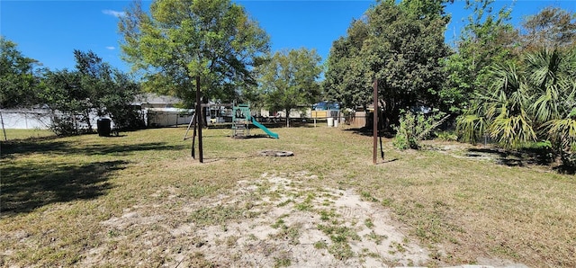 view of yard with a playground and a fenced backyard