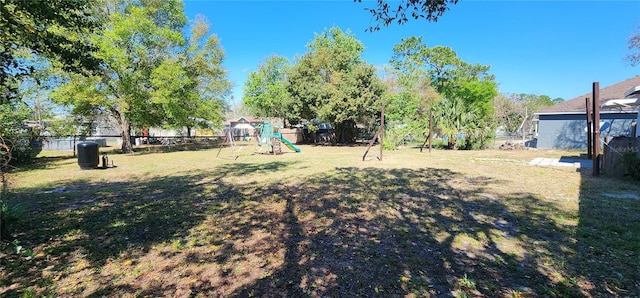 view of yard featuring playground community and fence