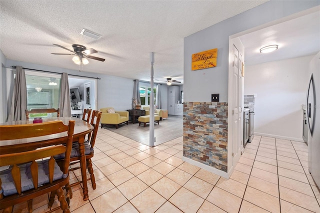 dining area featuring ceiling fan, a textured ceiling, and light tile patterned floors