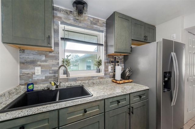 kitchen with decorative backsplash, sink, stainless steel fridge with ice dispenser, and green cabinets