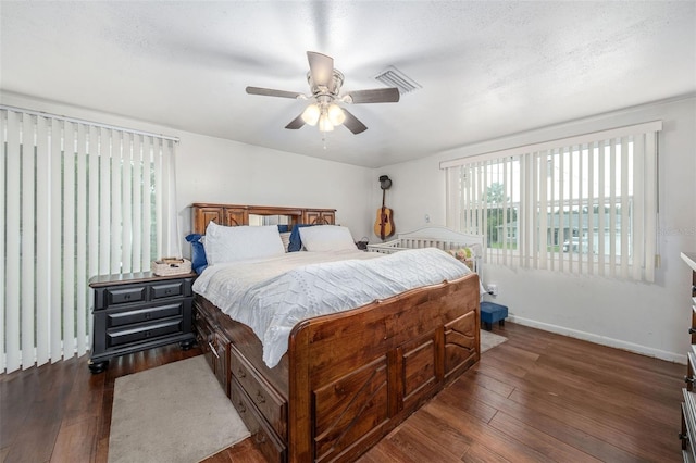 bedroom with ceiling fan, dark hardwood / wood-style floors, and a textured ceiling