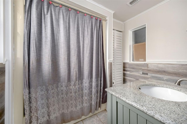 bathroom with tile walls, a shower with curtain, tile patterned floors, ornamental molding, and vanity