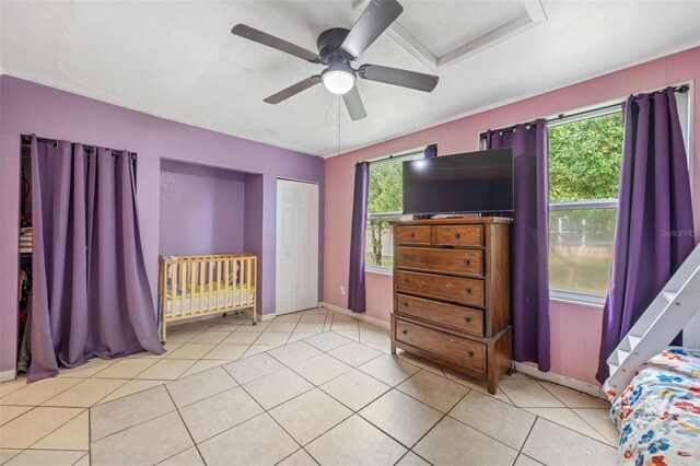 unfurnished bedroom featuring light tile patterned floors, ceiling fan, and a closet