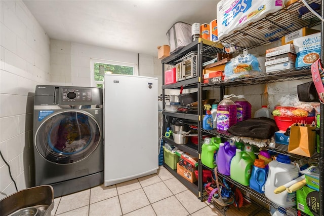 laundry room with washer / clothes dryer and light tile patterned flooring