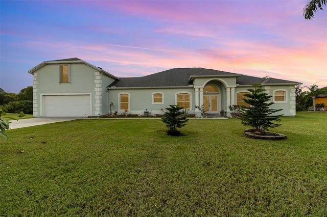 view of front of property with a yard and a garage