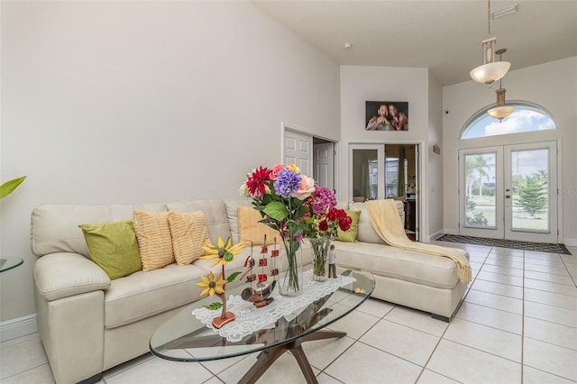 tiled living room featuring french doors and high vaulted ceiling