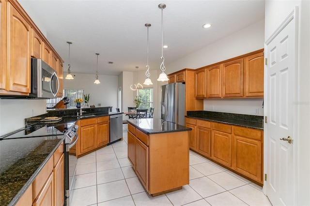 929 Hialeah St, Rockledge, FL 32955 - kitchen with dark stone countertops, hanging light fixtures, brown cabinets, stainless steel appliances, and a kitchen island