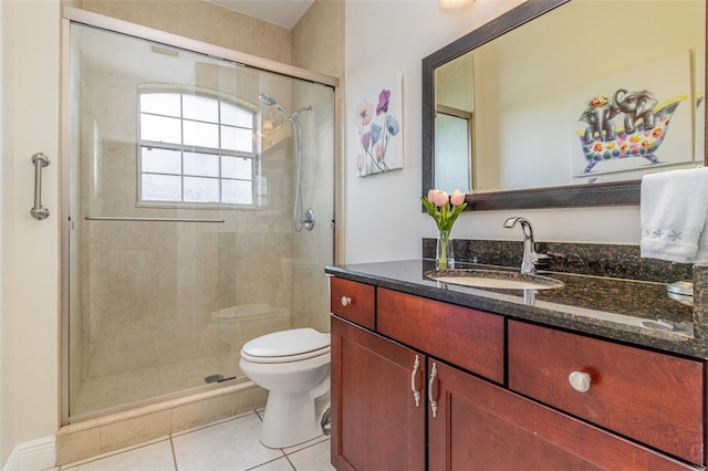 bathroom featuring vanity, toilet, a shower with door, and tile patterned floors