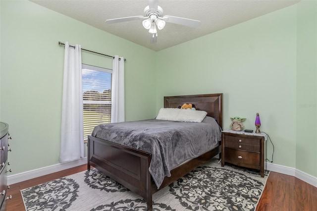 bedroom with ceiling fan, hardwood / wood-style flooring, and a textured ceiling