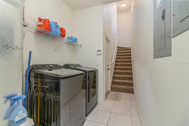 washroom with light tile patterned flooring, electric panel, and washer and dryer