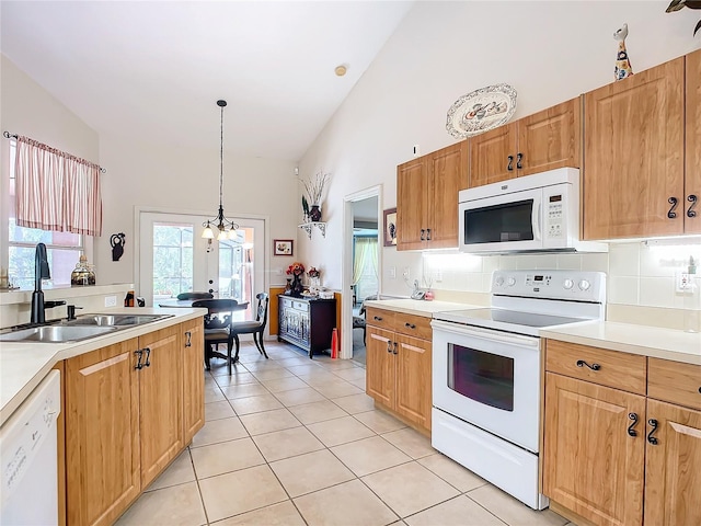 kitchen featuring pendant lighting, white appliances, high vaulted ceiling, sink, and light tile patterned flooring