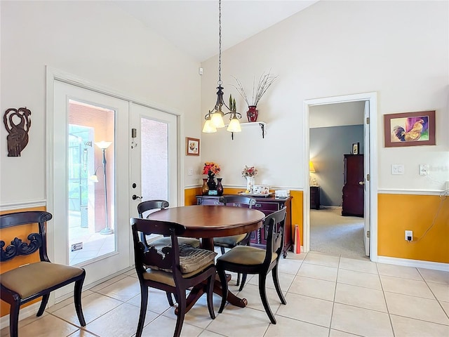 dining room with french doors, light tile patterned floors, high vaulted ceiling, and an inviting chandelier