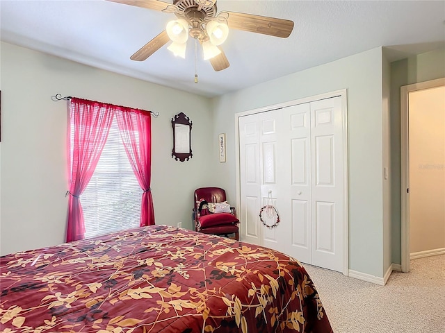 bedroom with ceiling fan, light carpet, and a closet