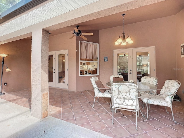 dining area featuring ceiling fan with notable chandelier, light tile patterned flooring, and french doors