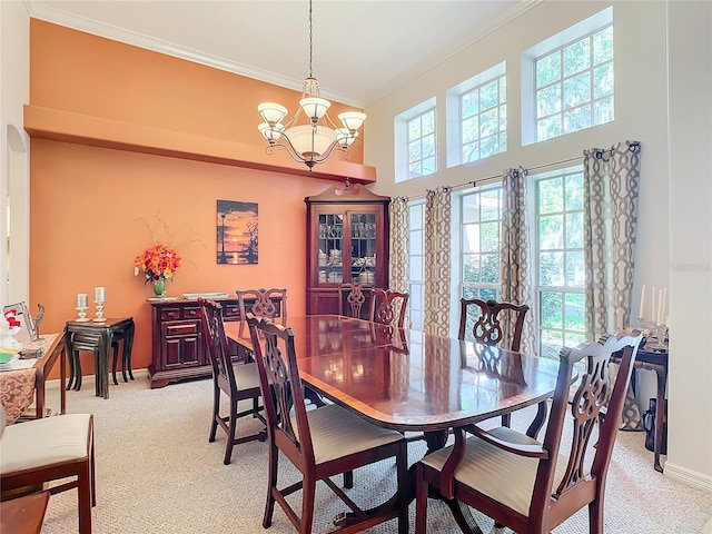 dining room with light colored carpet, ornamental molding, and a chandelier