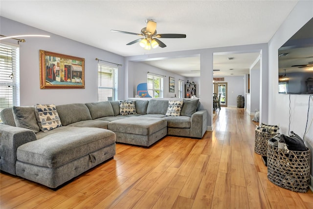 living room with light hardwood / wood-style flooring and ceiling fan