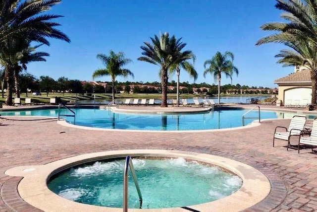 view of swimming pool with a patio area and a hot tub