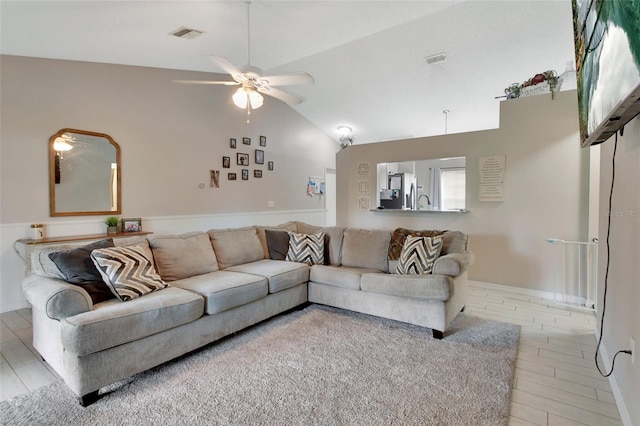 living room featuring ceiling fan, light wood-type flooring, and high vaulted ceiling