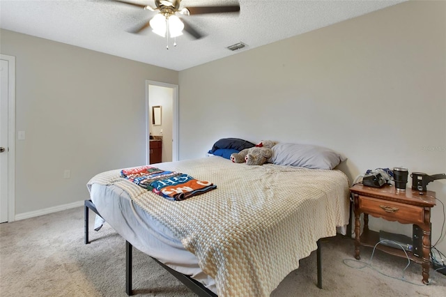 bedroom featuring a textured ceiling, ensuite bathroom, ceiling fan, and light colored carpet