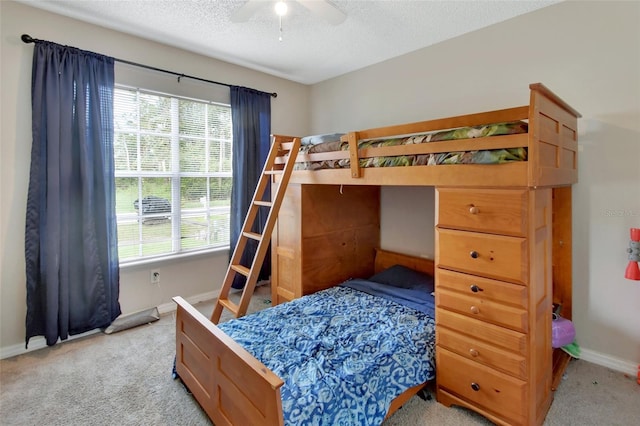 carpeted bedroom featuring ceiling fan, a textured ceiling, and multiple windows