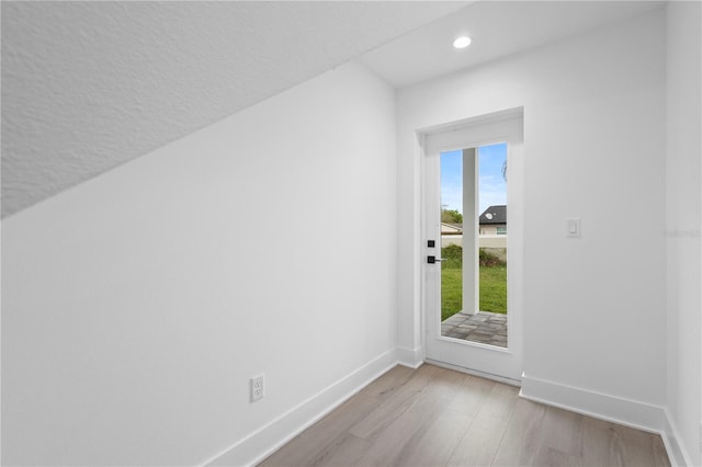 additional living space featuring light hardwood / wood-style floors and a textured ceiling