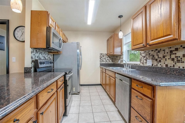 kitchen with sink, light tile patterned flooring, backsplash, stainless steel appliances, and pendant lighting