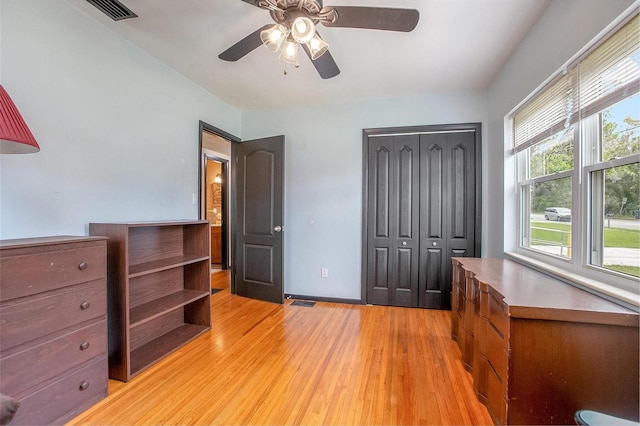 bedroom with a closet, light wood-type flooring, and ceiling fan