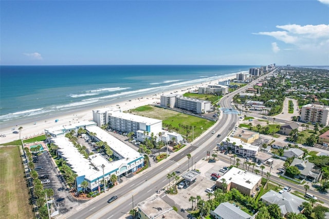 birds eye view of property featuring a water view and a beach view