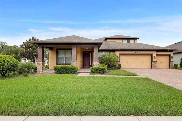 prairie-style home featuring a garage, a porch, and a front lawn