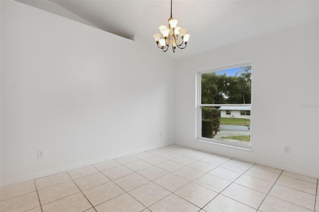 empty room with vaulted ceiling, an inviting chandelier, and light tile patterned floors