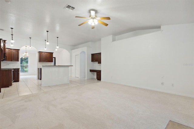 unfurnished living room with ceiling fan with notable chandelier and light tile patterned floors